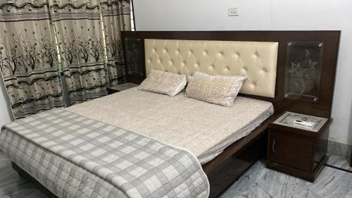 a bedroom with a bed with a headboard and a table at Little Haven Haveli - Luxury Heritage Homestay in Bikaner