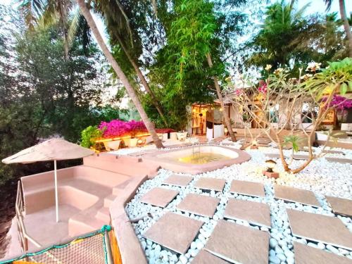 an outdoor patio with an umbrella and a fountain at Midsummer Night Dreams in Canacona