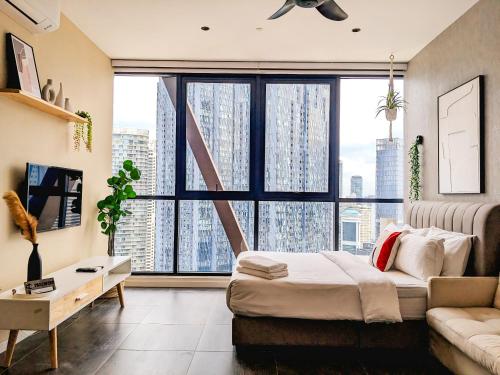a room with a large window with a bed and a couch at Scartlez suites KLCC by Dream in Gua Sai