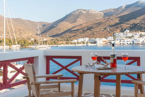 a table with two glasses of wine on a balcony at Nicolas House 1 in Rakhídhion