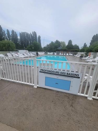 une porte en face d'une piscine dans l'établissement Bungalow charmant à Ivry-la-Bataille avec piscine partagée, à Ivry-la-Bataille