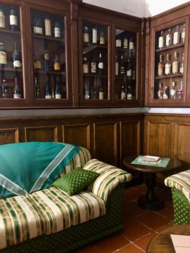 a room with a couch and some shelves with bottles at La Caveja in Pietravairano