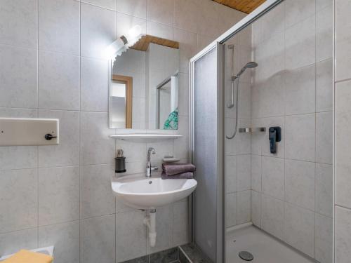 a white bathroom with a sink and a shower at Haus am Wildbach in Auffach