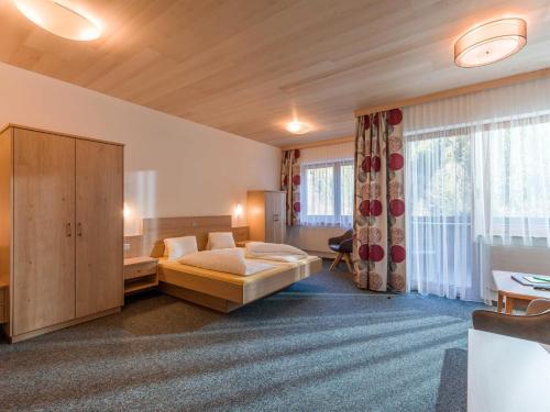 a hotel room with a bed and a large window at Haus am Wildbach in Auffach