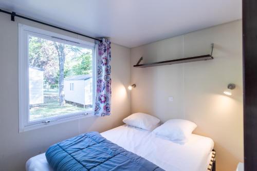 une chambre avec un lit et une fenêtre dans l'établissement Mobilhome Du Bonheur, à Saint-Pompont