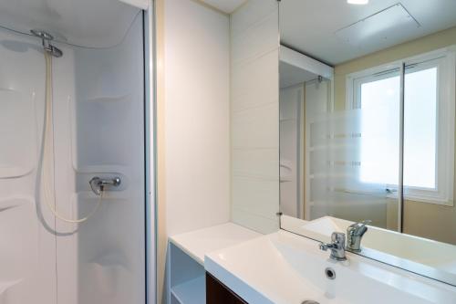 une salle de bain avec lavabo et douche dans l'établissement Mobilhome Du Bonheur, à Saint-Pompont