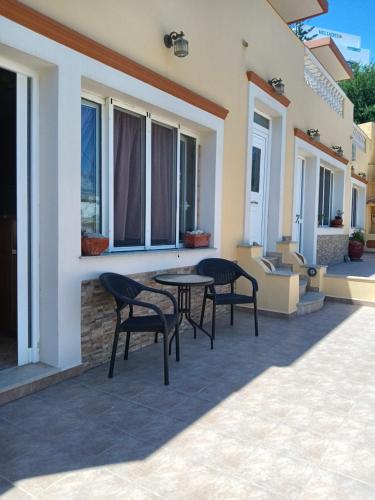 a patio with two chairs and a table on a house at Theodore's Mansion Your aristocratic escape in Greece in Panteli