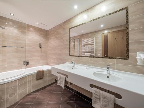 a bathroom with two sinks and a tub and a mirror at Haus Annakogl und Haus Barbara in Obergurgl