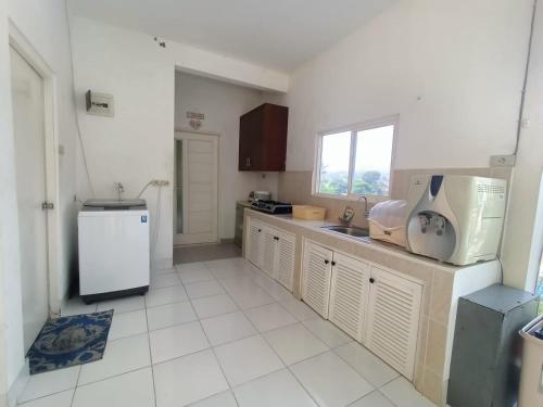 a kitchen with a sink and a refrigerator at Villa Kaca 88 in Cinengangirang