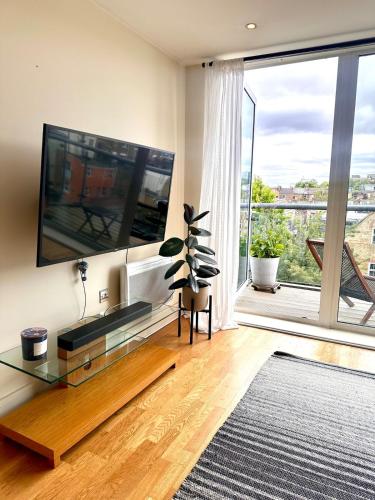 a living room with a large flat screen tv on a wall at Flat in Arsenal Islington Central London in London
