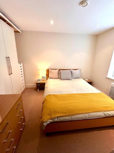 a bedroom with a large bed with a yellow blanket at Flat in Arsenal Islington Central London in London