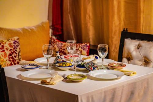 a table with plates of food and wine glasses on it at Hotel Andalucia Tangier in Tangier