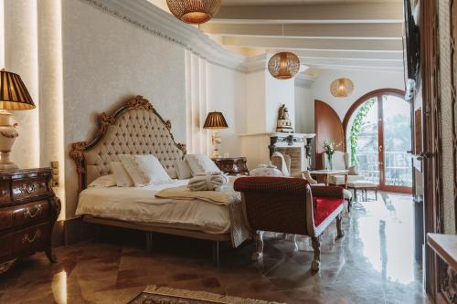 a bedroom with a large bed and a chair at Los Pilares de Ronda Boutique & Hotel in Ronda