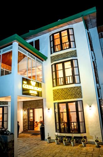 a white building with windows and potted plants at The Golden Legacy Hotel in Nuwara Eliya