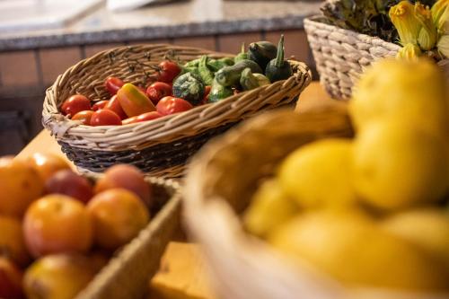 a table with baskets of fruits and vegetables on it at Casa Rosaria Amalfi Coast in Vietri sul Mare