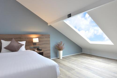 a bedroom with a white bed and a window at The Chill at Krabi Hotel in Krabi town