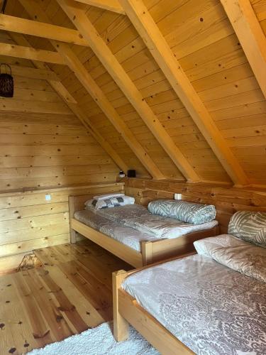 a room with two beds in a wooden attic at Komovi-Apartment in Kolašin