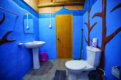 ein blaues Badezimmer mit Toilette und Waschbecken in der Unterkunft The Travel Tree Hostel in Sigiriya
