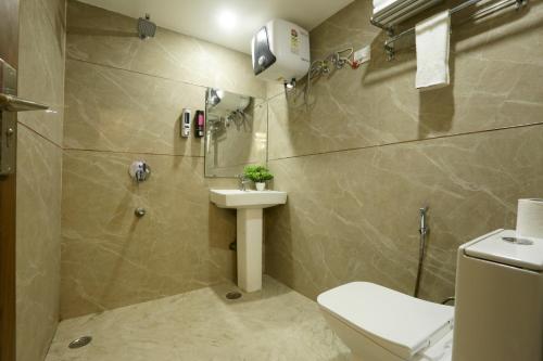a bathroom with a toilet and a sink at Hotel Mehak Palace By Aura in Noida