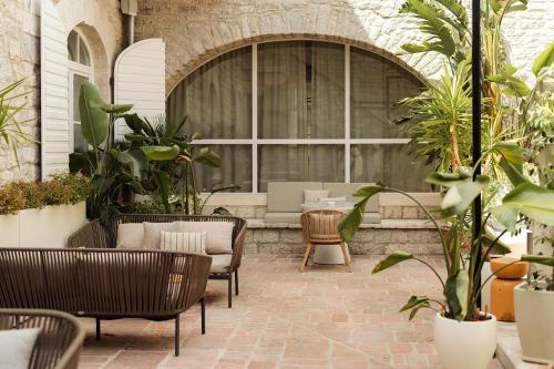 a patio with chairs and tables and plants at Lazure Hotel & Marina in Herceg-Novi