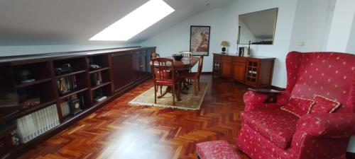 een woonkamer met een rode bank en een tafel bij El Ático de Frida in Vigo