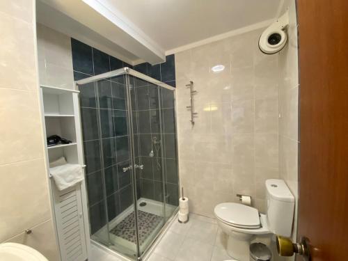 a bathroom with a toilet and a glass shower at Arantes and Oliveira in Lamego