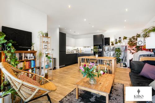 a living room with a vase of flowers on a table at Penthouse Hackney Wick with Balcony, gym, rooftop in London