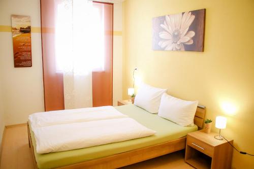 a small bedroom with a bed with a window at XXL-Ferienwohnung Blumenwiese in Hayingen