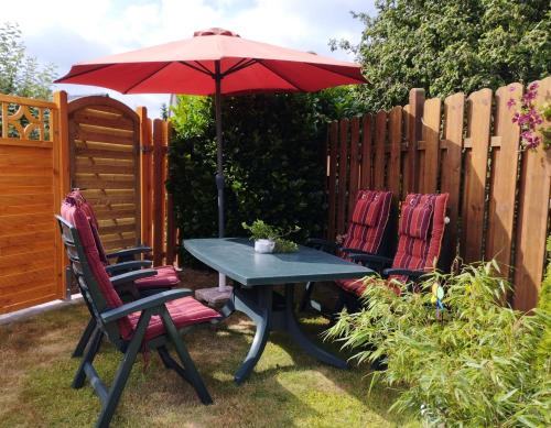 a table and two chairs with an umbrella at Ferienwohnung Moi Tied 35677 in Uplengen