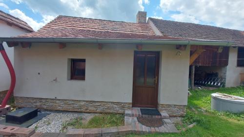 a small white house with a brown door at Prázdninový dům in Habří