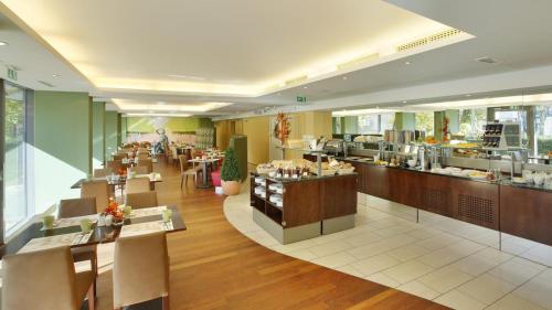 a restaurant with tables and chairs and a cafeteria at Ibercity Wien Schönbrunn in Vienna