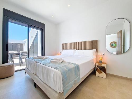 a bedroom with a large bed and a mirror at Villa Verano San Javier - 6610 in San Javier
