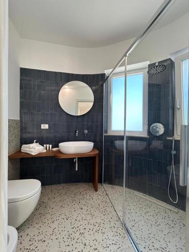 a bathroom with a sink and a toilet and a shower at Le Dimore di Fefè in Alberobello