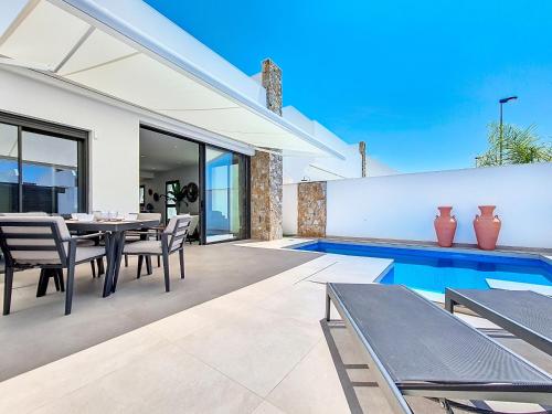 a patio with a table and chairs and a swimming pool at Villa Verano San Javier - 6610 in San Javier
