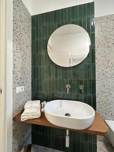 a green tiled bathroom with a sink and a mirror at Le Dimore di Fefè in Alberobello