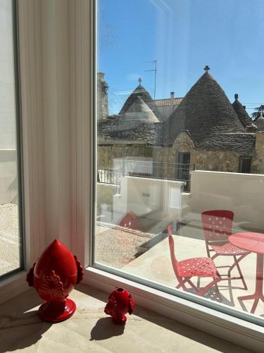 a window with two red chairs and a table at Le Dimore di Fefè in Alberobello