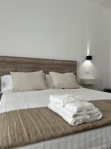 a bed with two white towels sitting on it at Le Dimore di Fefè in Alberobello