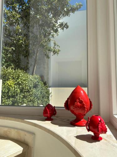 a red vase sitting on a window sill at Le Dimore di Fefè in Alberobello
