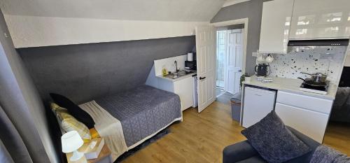 a small room with a bed and a kitchen at Fantastic 4 Apartments in Dagenham Dock