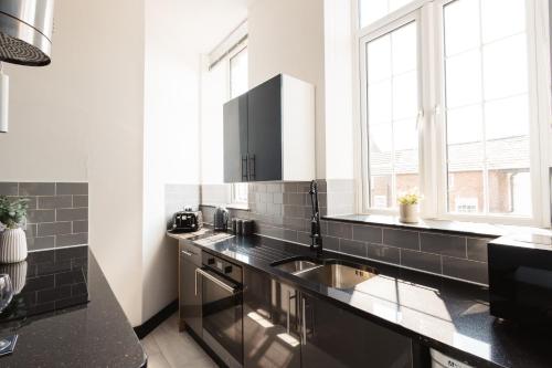 a kitchen with a sink and a counter top at Stylish Town Centre Suite by Traboule Properties LTD in Warrington