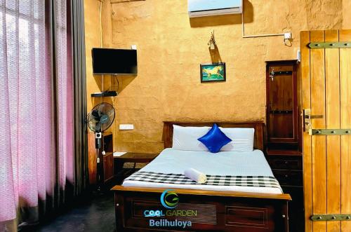 Un dormitorio con una cama con una almohada azul encima. en Cool Garden belihuloya, en Belihuloya