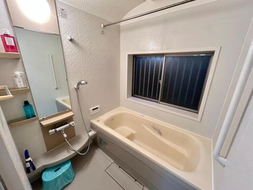 un bagno con vasca e finestra di AiES新小岩 新小岩站走8分 繁华商店街旁 最大12人 直达机场秋叶原新宿 旅馆内带免费停车场庭院露台 邻公园 a Tokyo