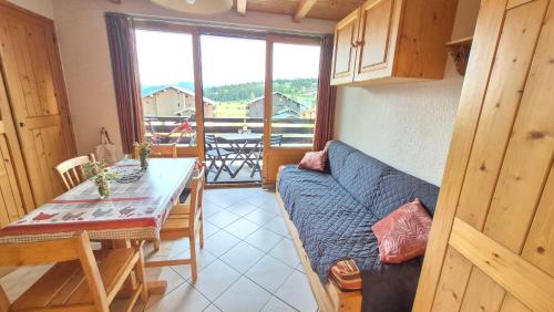 un salon avec un canapé bleu et une table dans l'établissement Appartement lumineux station Les Saisies 100 M des pistes et ESF, à Hauteluce