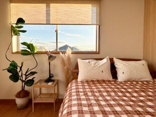 una camera da letto con un letto e una grande finestra di AiES新小岩 新小岩站走8分 繁华商店街旁 最大12人 直达机场秋叶原新宿 旅馆内带免费停车场庭院露台 邻公园 a Tokyo