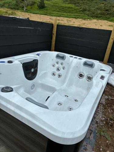 a white bath tub sitting in a yard at Lerags glen farm pods in Lerags