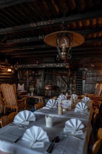 a dining room with tables and chairs and a chandelier at Berghotel Blaickner's Sonnalm in Zell am See