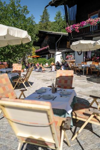 a table and chairs and umbrellas in a patio at Berghotel Blaickner's Sonnalm in Zell am See