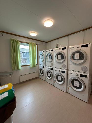a laundry room with four washer and dryer machines at Camp Skytterhuset in Hammerfest