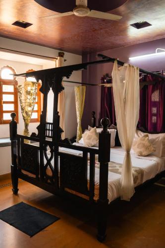 a bedroom with a black bed with curtains on it at Jaisalmer Elite Castle in Jaisalmer