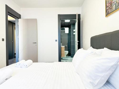 a bedroom with a white bed with towels on it at Adriatic Masterpiece Residence in Sveti Stefan